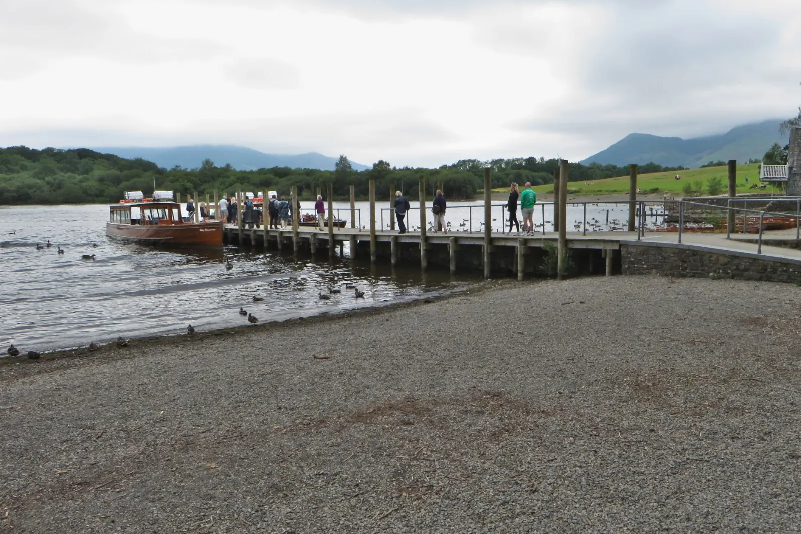 Passengers on the wooden landing stages at Keswick beside a launch