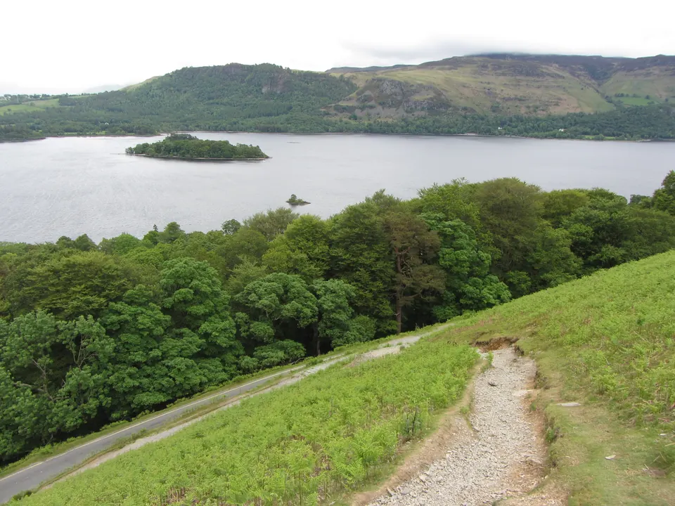 The stony path leaving the narrow road at the foot of Catbells, with Derwentwater behind